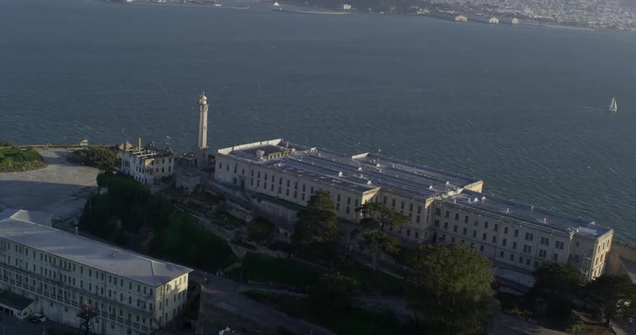 Alcatraz prison sits on an island in san francisco bay as a sailboat passes by