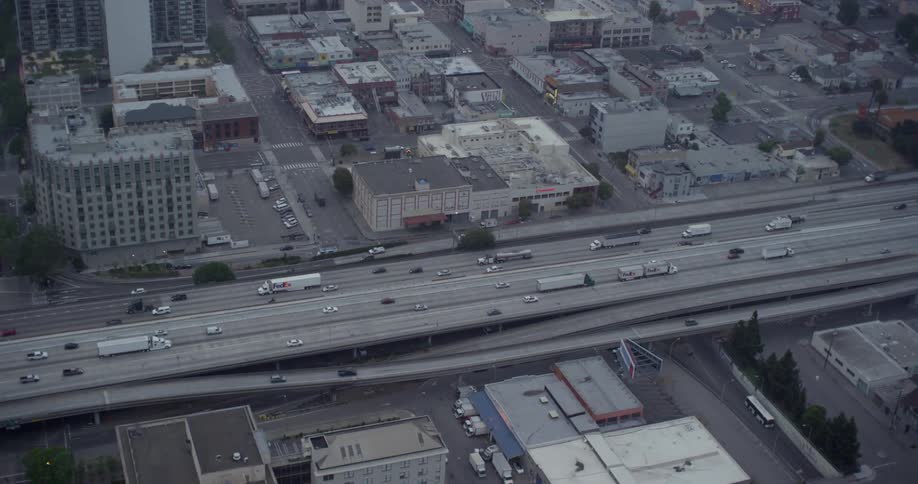 Trucks and cars drive down an interstate in a city