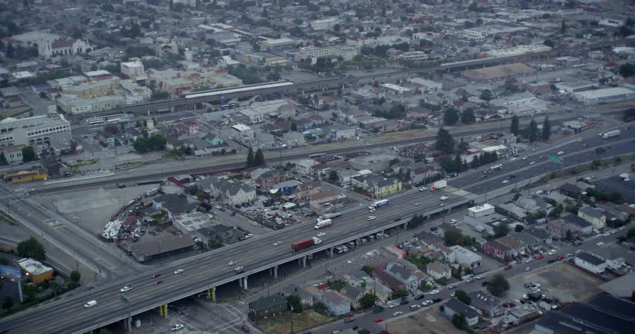 Traffic traveling along a highway through a city during the day