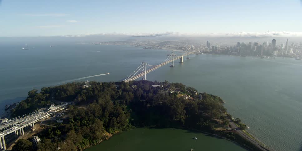 Aerial view of the water with boats in it and a bridge heading in to the city