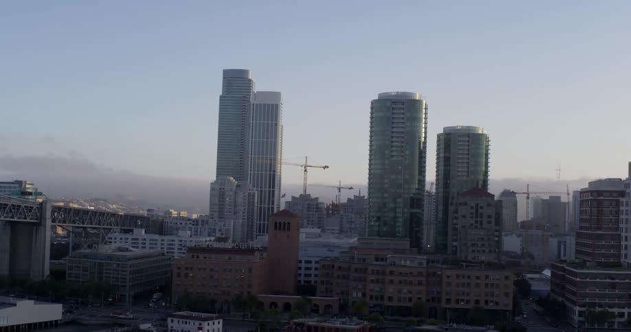 City buildings sit next to a bridge that goes over a river