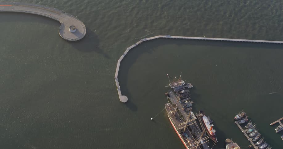 Boats sit at the dock in the river with piers nearby