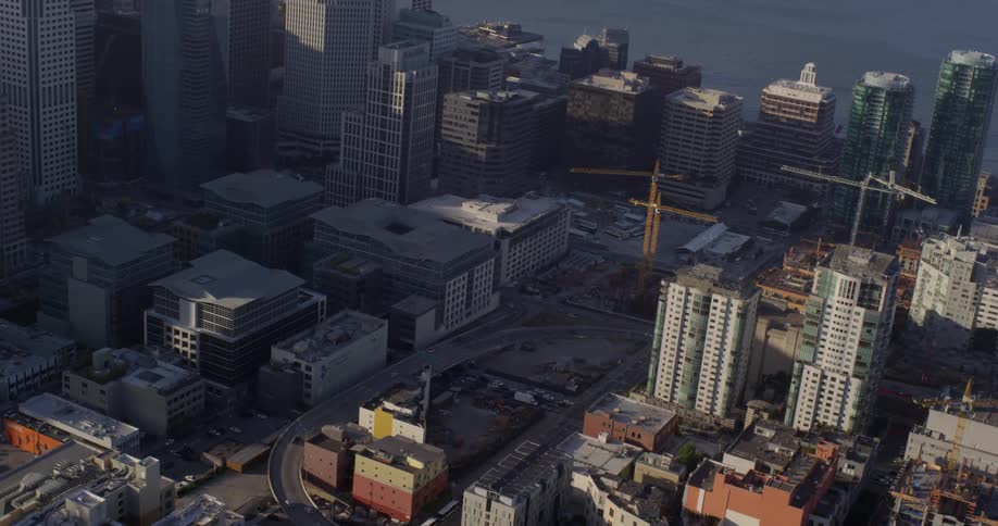 Aerial view of a downtown area with office buildings and cars right off the water