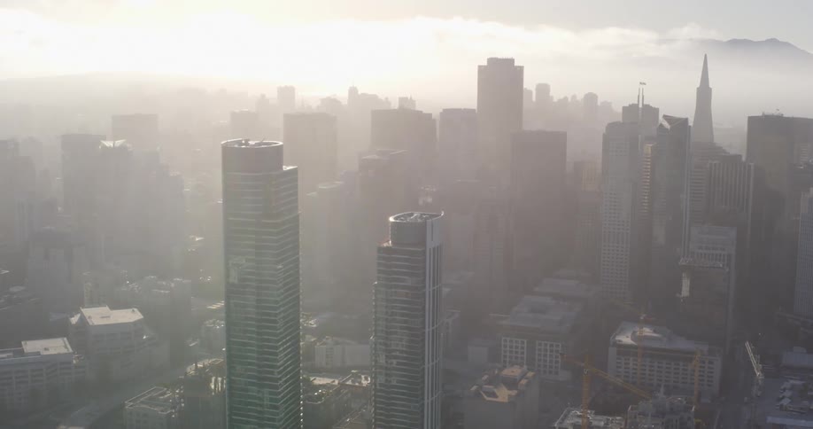 An aerial view of a downtown city is displayed at dusk