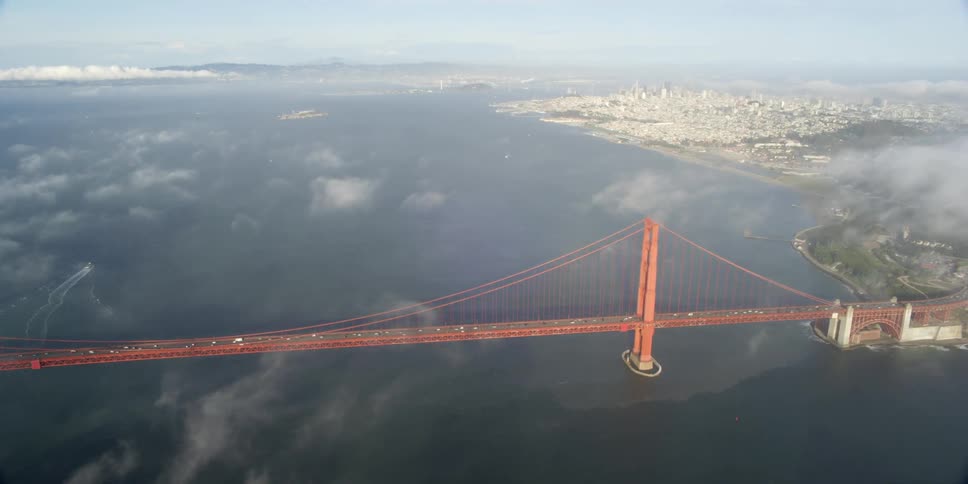 An aerial view of the golden gate bridge as traffic moves across it