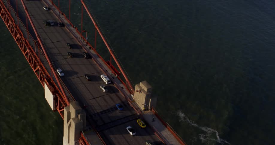 Aerial view of vehicles driving across a bridge