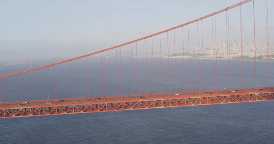 Cars are driving on a bridge above the ocean