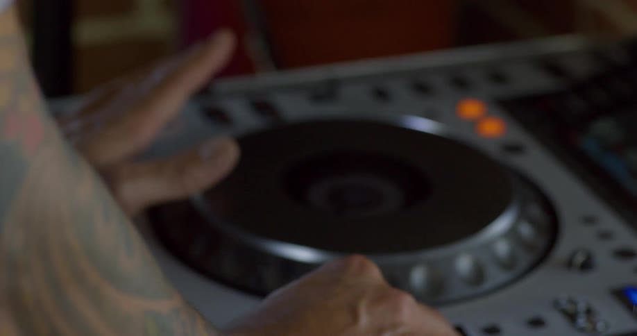 Close up of disk jockey hands using electronic equipment