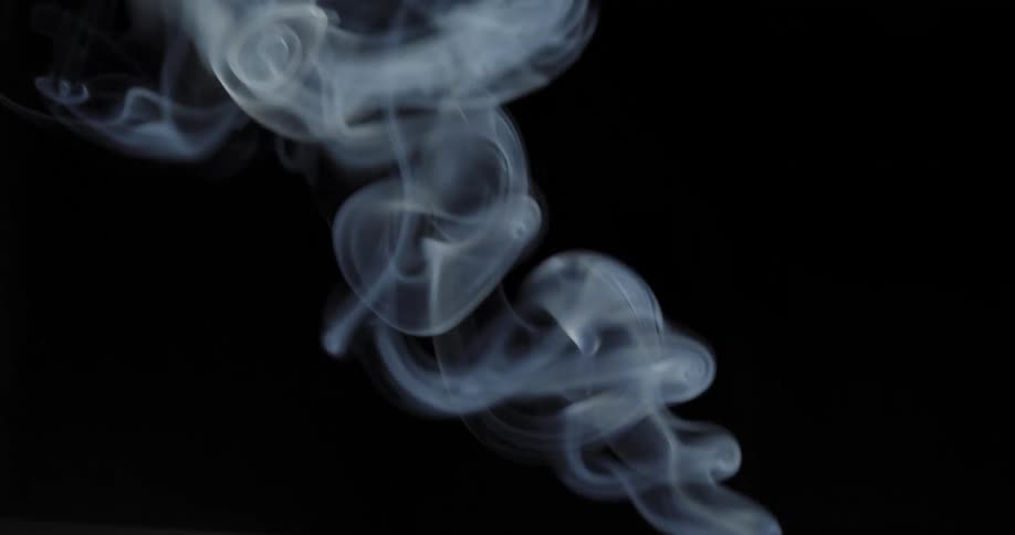 The smoke swirls and rises in the dark