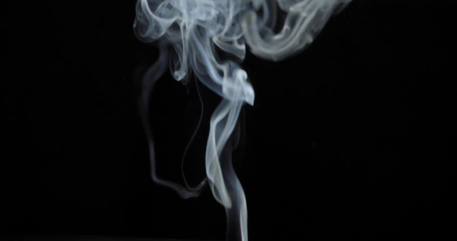 Smoke rising up against a black background