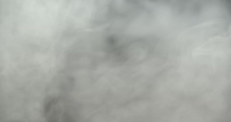 Puff of smoke rising up against a black background