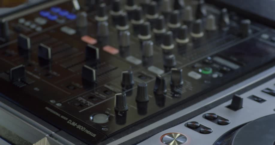 A man moves controls on a soundboard