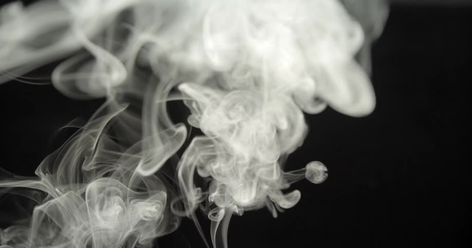 Puffs of smoke rising up against a black background