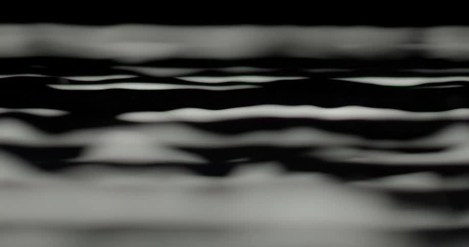 Very close shot of waves and ripples in water
