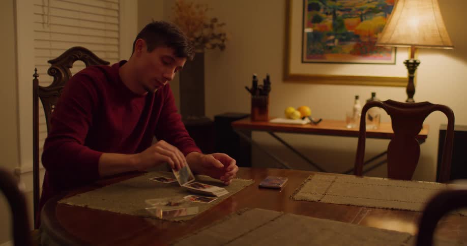 A young man sitting at home playing cards