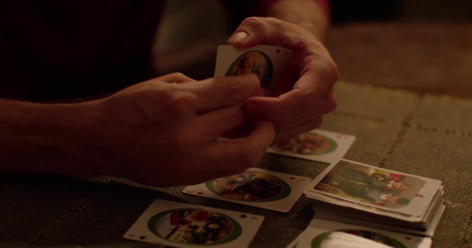 A person is using playing cards on the table