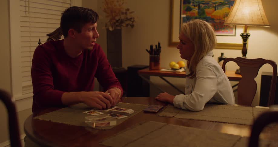 A man and a woman sitting at a dining room table talking