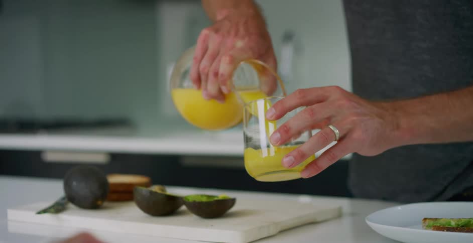 A person is pouring juice into a glass