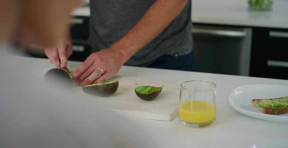 Spreading avocado on toast for breakfast
