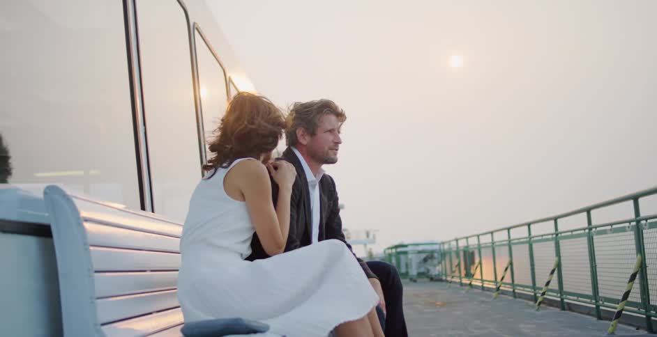 Couple sitting on a bench while traveling on a ferry boat