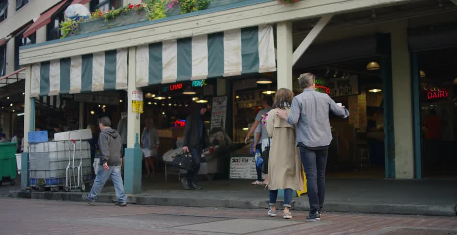 A man hugging a woman while they walked towards the store
