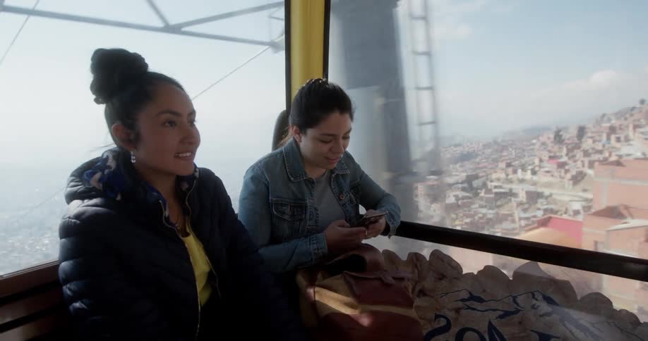 Woman sitting on a cable car going over the city