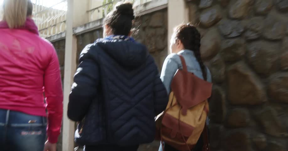 Group of teenage girls walking on the sidewalk at day