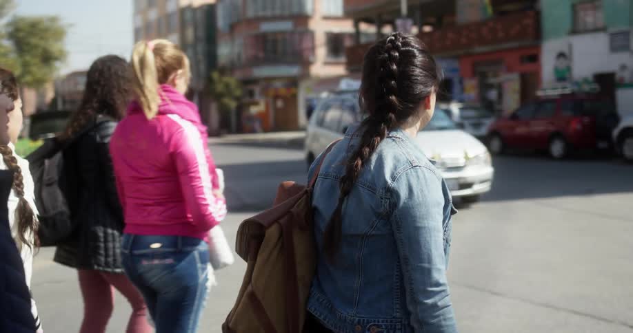 Three girls cross the street together