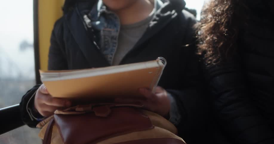 A girl pulls a notebook out of her bag