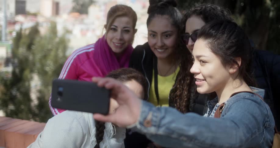 A group of young ladies smile and pose for a selfie