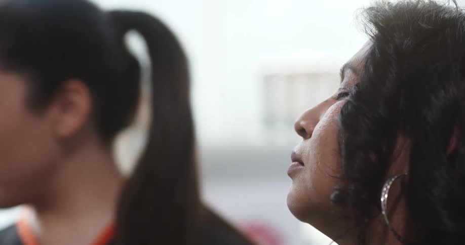 A worker at a beauty salon applies wax to a womans eyebrow