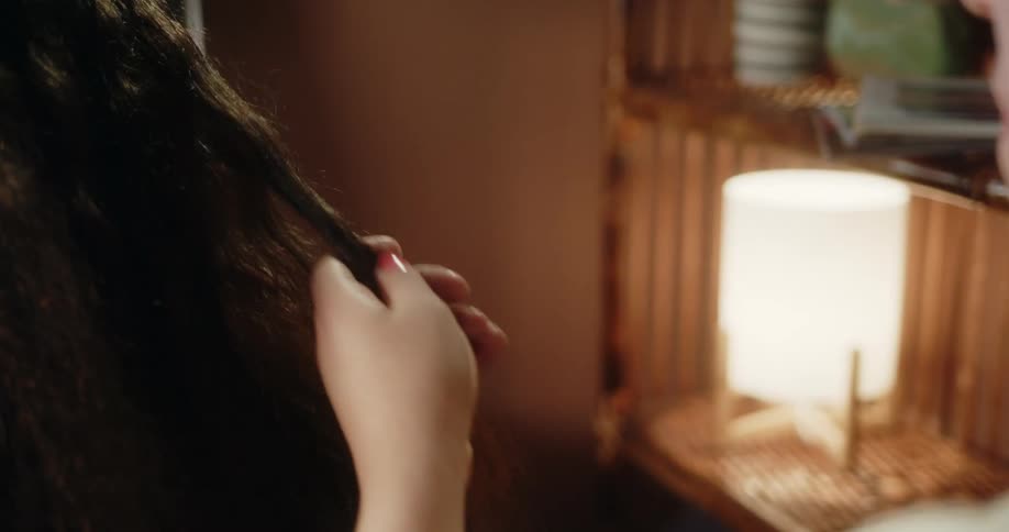 A woman smooths out another persons extremely long hair in preparation for cutting it