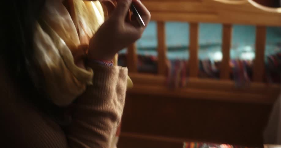 A teenager sits in her bedroom and puts make up on