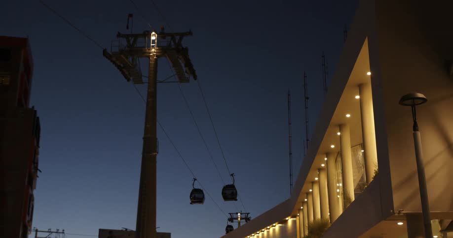 Cable cars go up and down the towers over the city at sunset