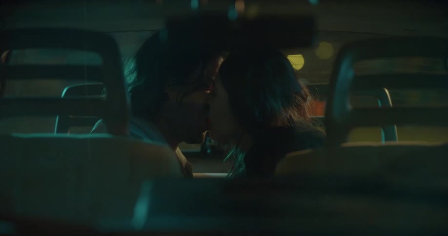A man and a woman sitting in a car kissing