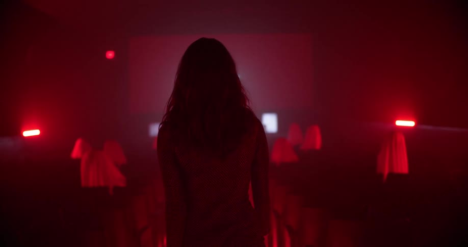 A woman walking down an aisle in a theatre