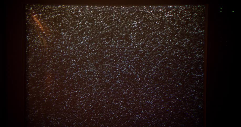 Vintage television screen shows static in a dimly lit room