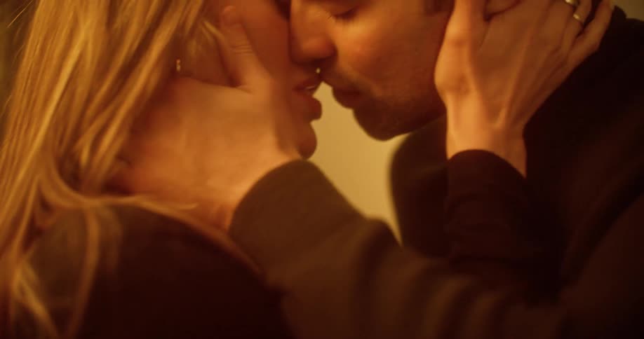 A man and woman passionately kissing in a room