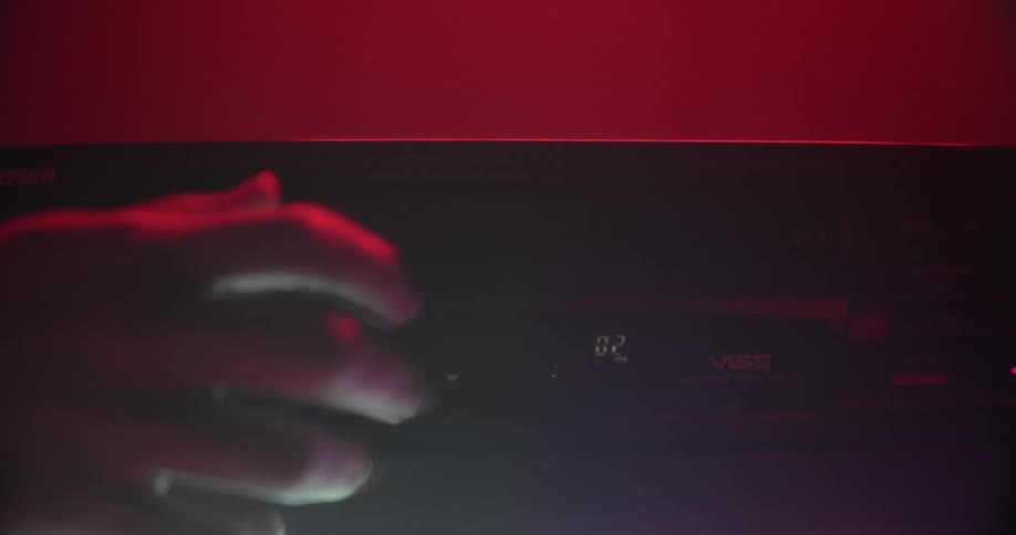 A person inserts a vhs tape into a player