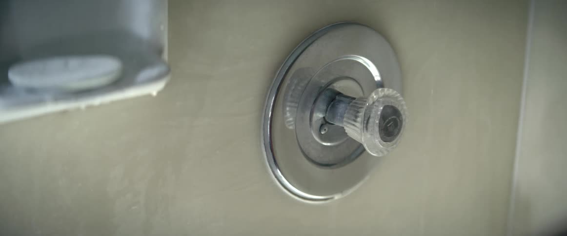 Man pulls and pushes the faucet of a shower in the bathroom