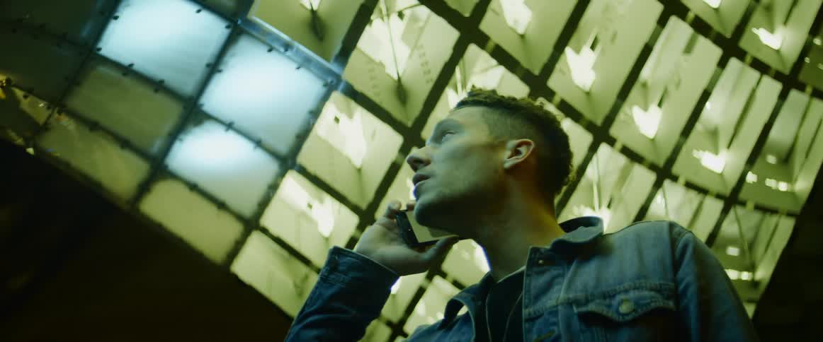 Man speaks on the cellphone under green lights at night