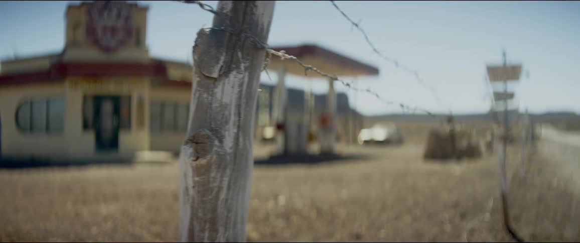 Barbed wire fence runs near the gas station in the rural countryside