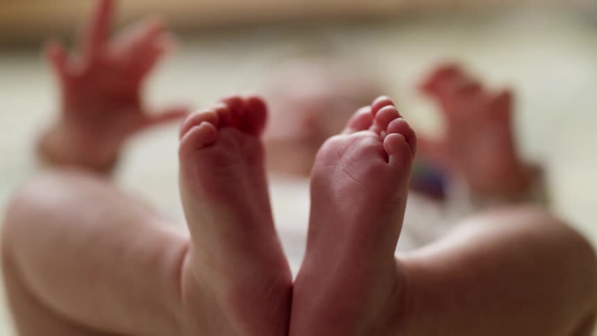 A baby is playing in the bed