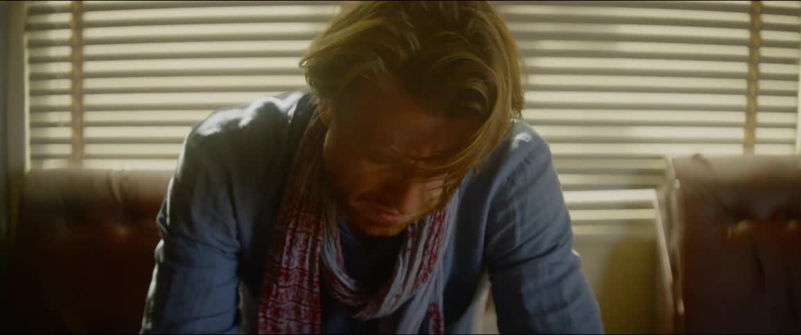 Upset man witha stubble beard sits in a chair