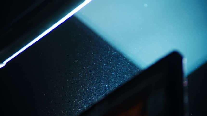 Tablet moves crosses in front of particles glinting in light