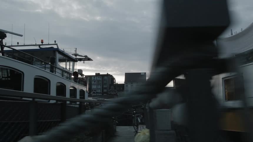 Several large ships are docked near some buildings