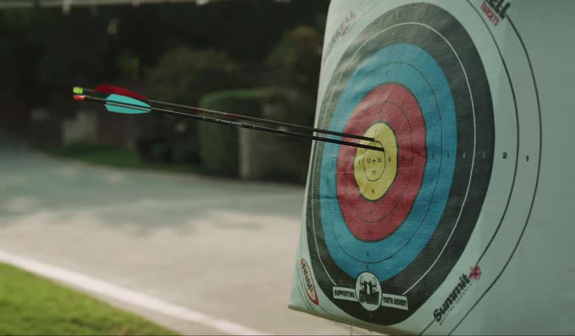 An arrow strikes an archery target in the bullseye
