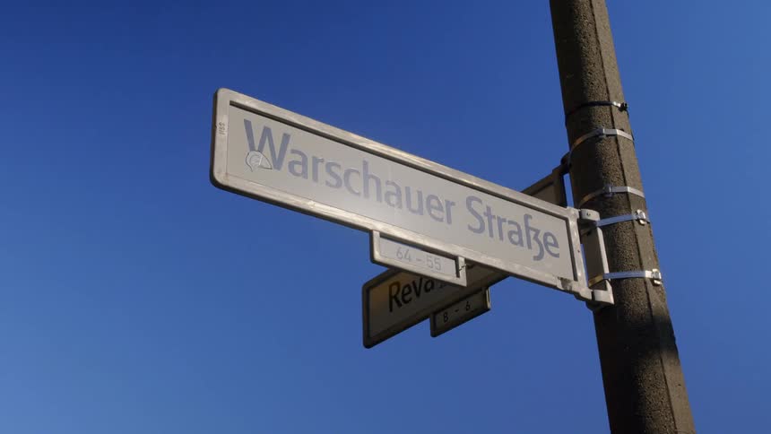 Metal straps hold street signs to a pole