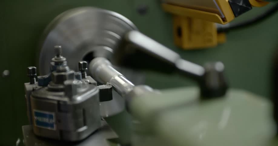 Water droplets fly off a tool as it works in a factory