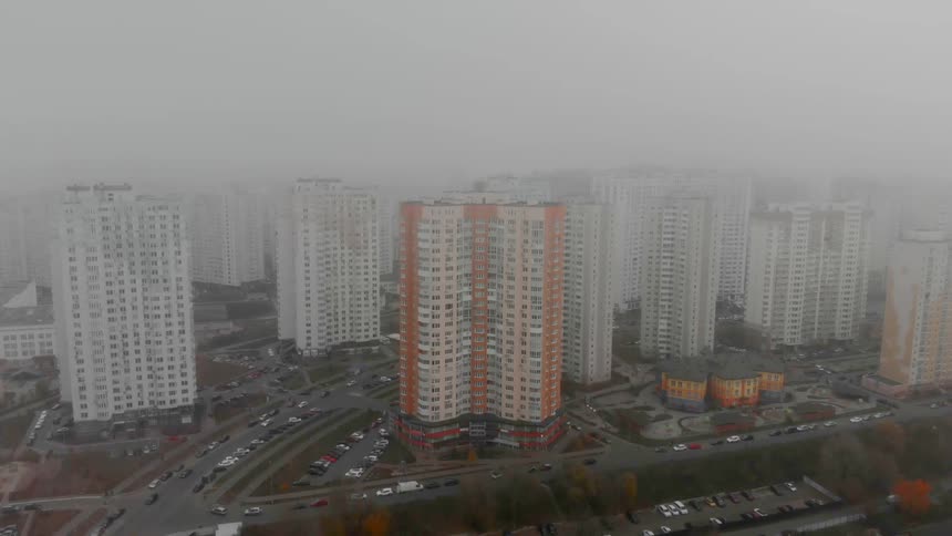 Aerial view of block of flats with roads and highways on a foggy day